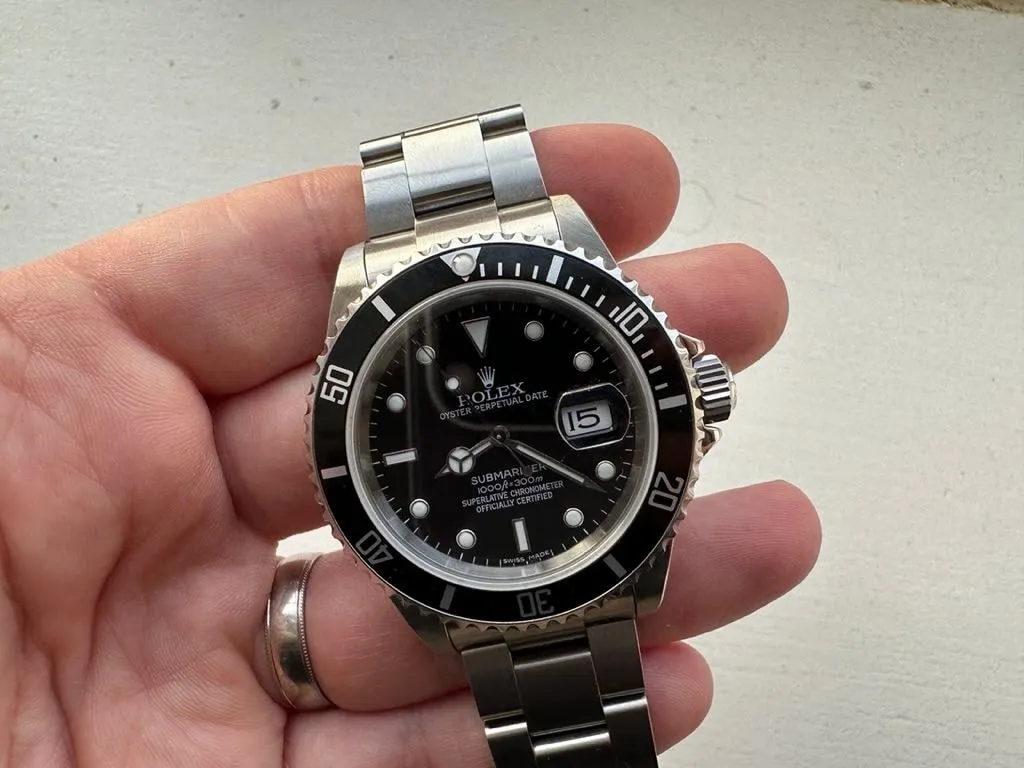 Finished Submariner 16610 franken build held in the hand on its Oyster bracelet