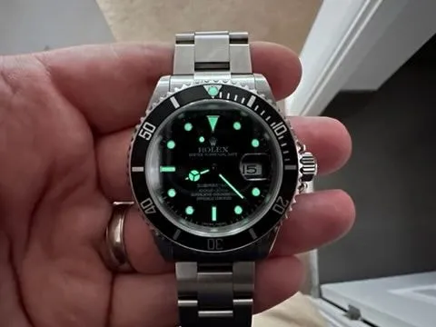 The finished 16610 build's lume glowing green on the dial and bezel pip